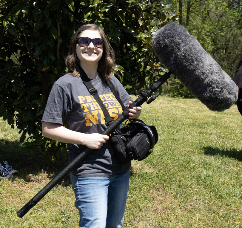 Hannah Robertson holding a boom mic outdoors